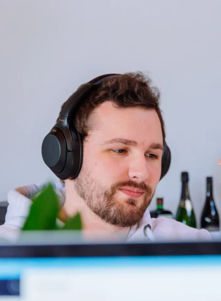A designer in headphones, focused on the screen in front of him